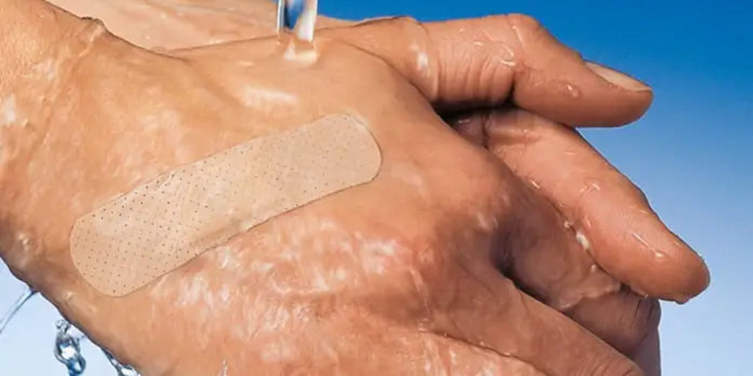 Hand with a bandage on a clear blue sky background