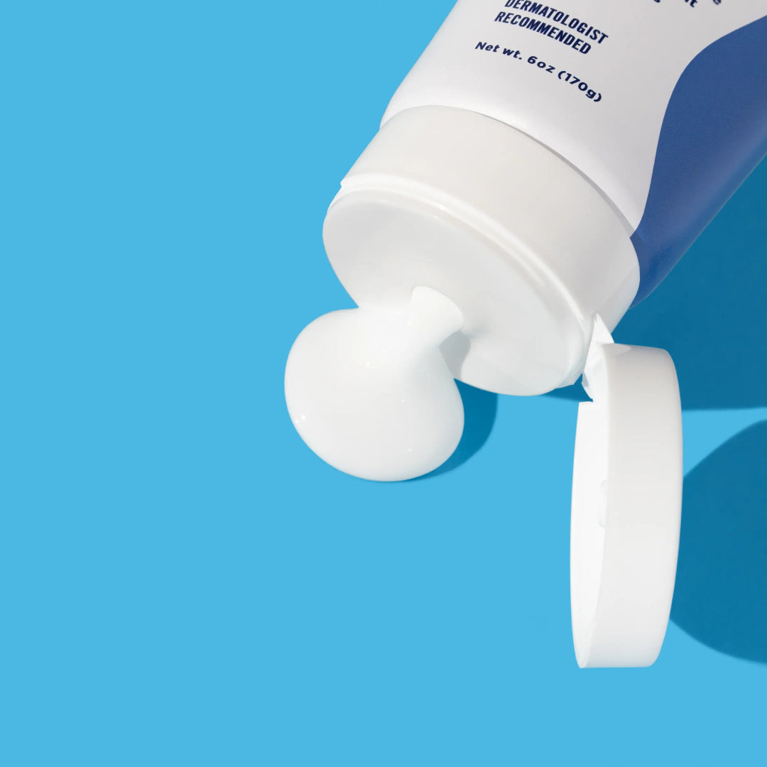 White tube of cream with blue label on a blue background