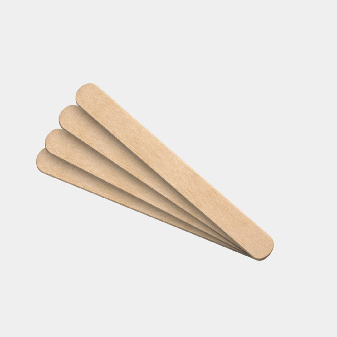 Three wooden tongue scrapers on a light gray background