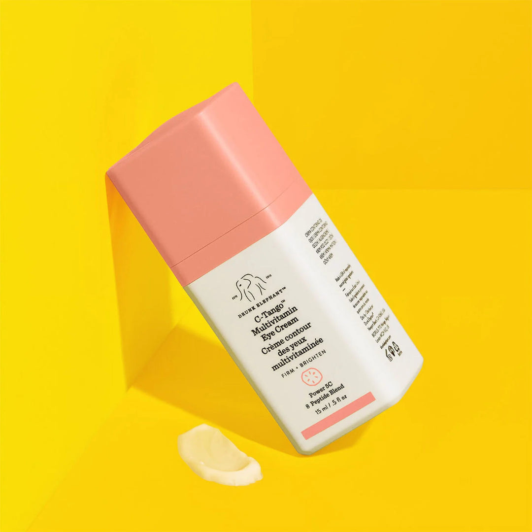Cosmetic tube with pink cap and white label on a yellow background