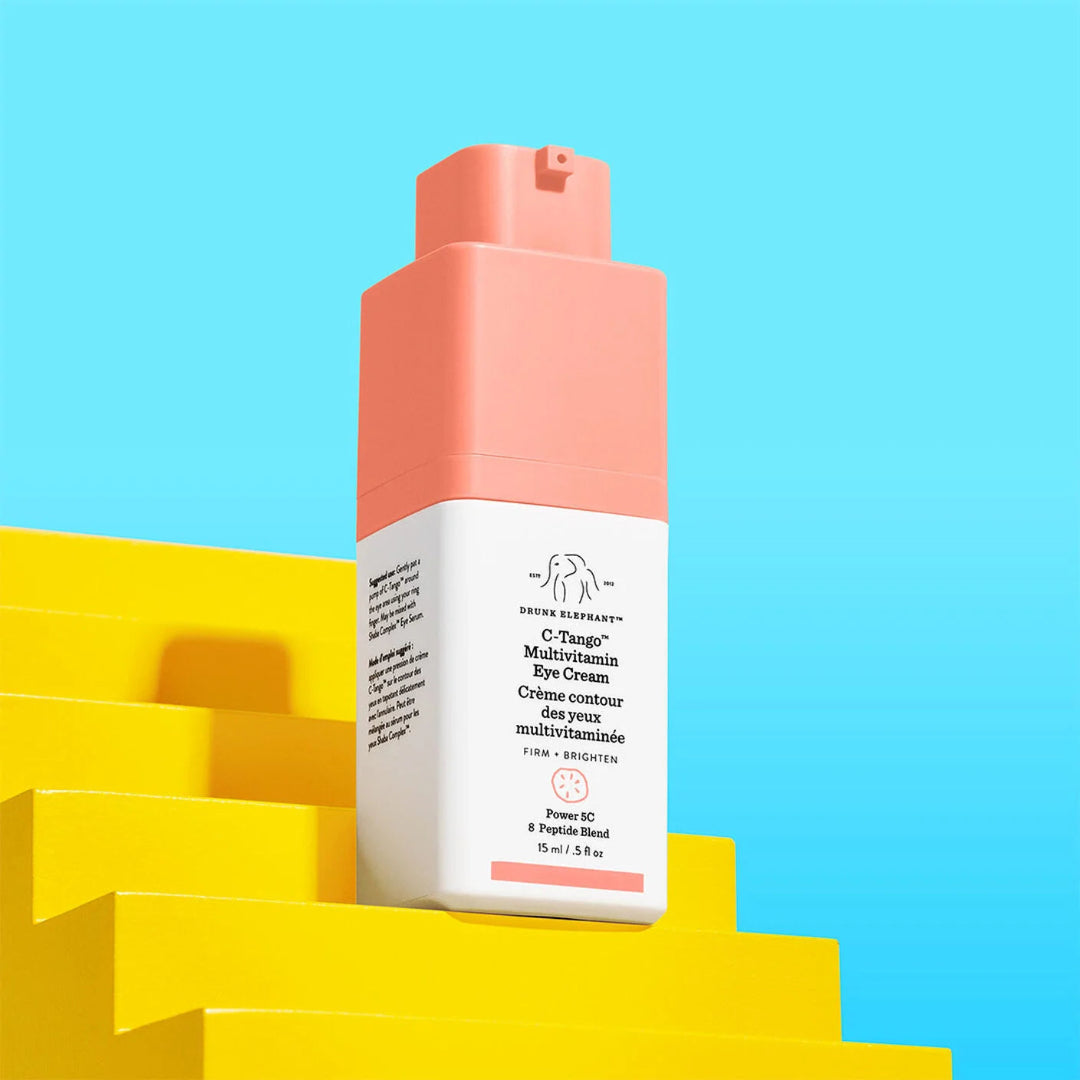 Pink and white skincare product on a yellow step with a blue background
