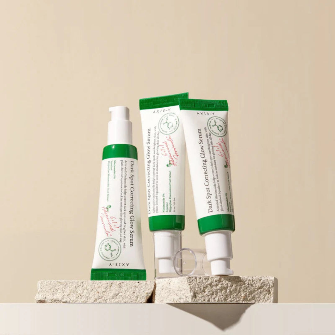 Three skincare products with green and white packaging on a beige background
