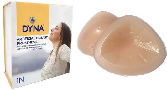 DYNA artificial breast prosthesis packaging and two beige prostheses on a white background