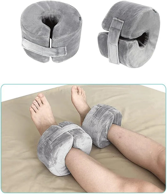 Gray travel pillow with adjustable straps on a beige surface.