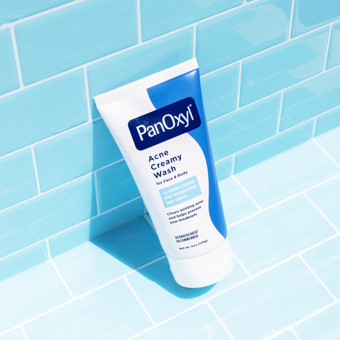 PanOxyl Acne Creamy Wash tube on a blue tiled background