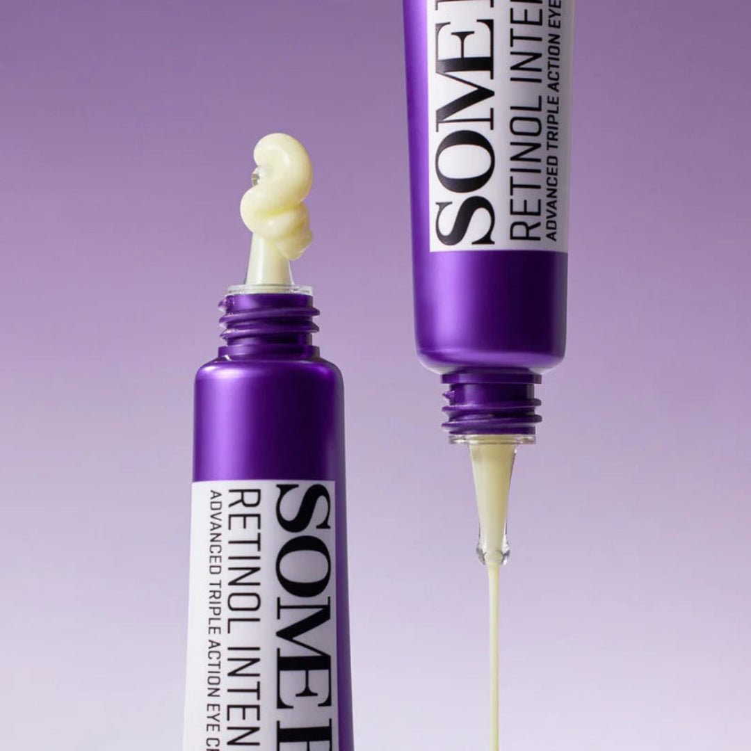 Two purple eye serum bottles with visible cream on a purple background