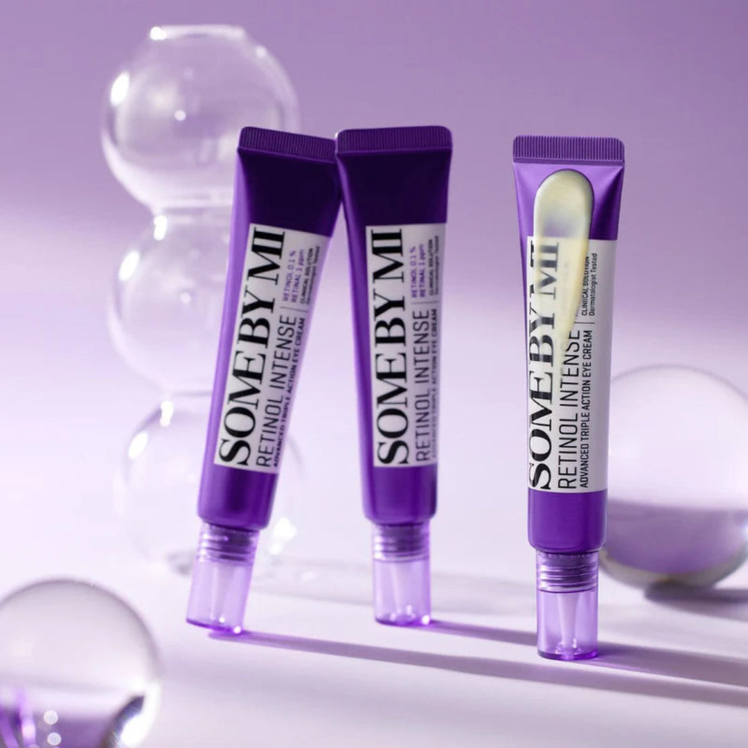 Three purple eye cream tubes labeled 'Some by Mi' on a light purple background