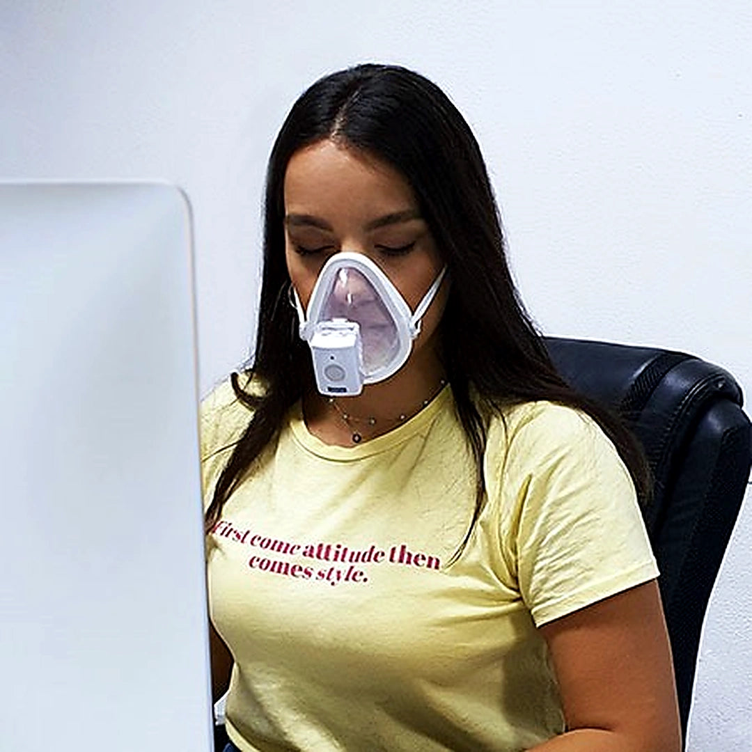 Person wearing an oxygen mask with a yellow shirt featuring text.