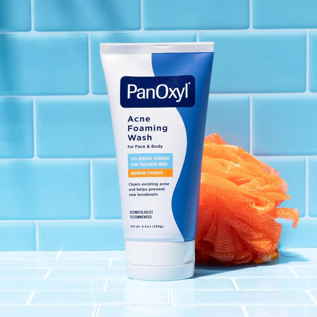 PanOxyl Acne Foaming Wash tube with an orange loofah on a blue tiled background